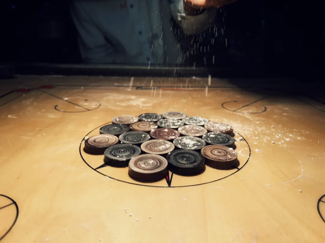Carrom Pulver wird auf einer Spielfläche verteilt