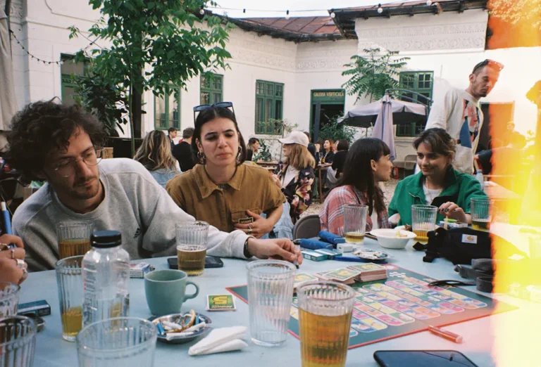 Gruppe sitzt gemeinsam an einem Spieltisch als Symbol für unterschiedliche Spielrunden und Regelsets