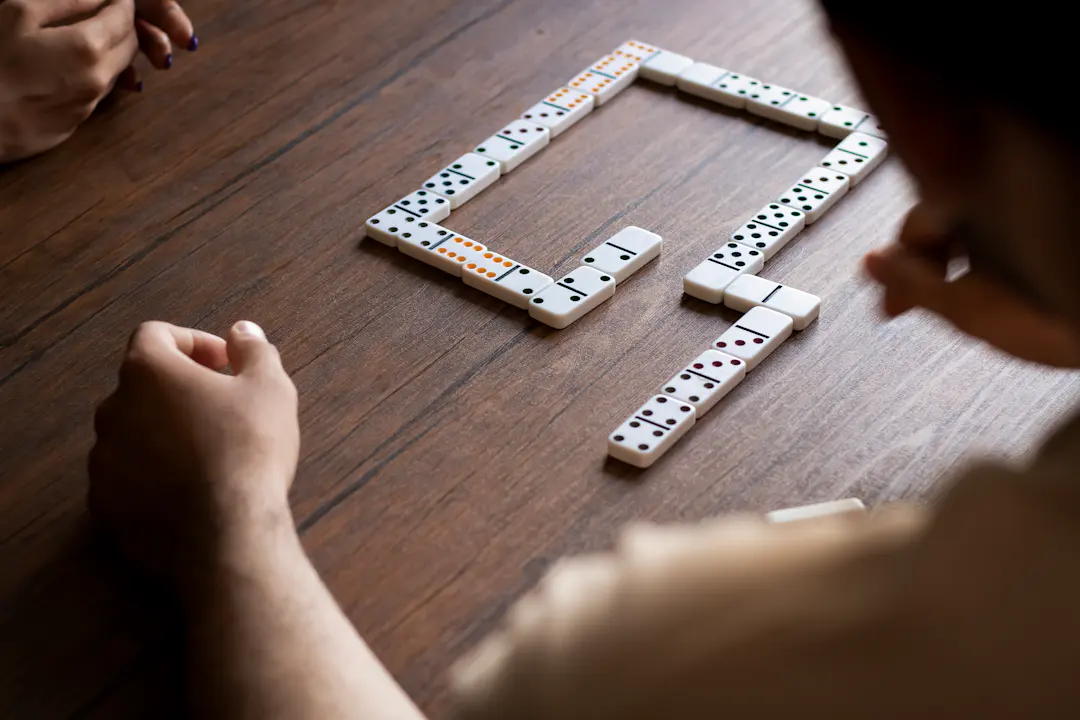 Person spielt Domino an einem Tisch