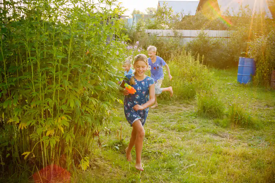 Kinder spielen ausgelassen draußen im Garten als Motiv für gemeinsame Gartenspiele in der Familie