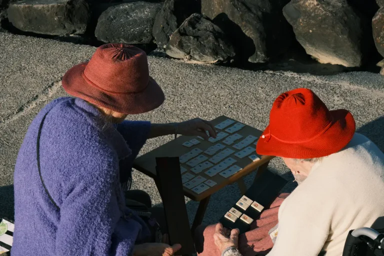 Zwei ältere Erwachsene konzentrieren sich gemeinsam auf ein Spiel