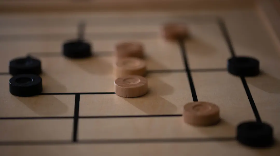 Mühlespiel aus Holz mit hellen und dunklen Spielsteinen auf dem Brett