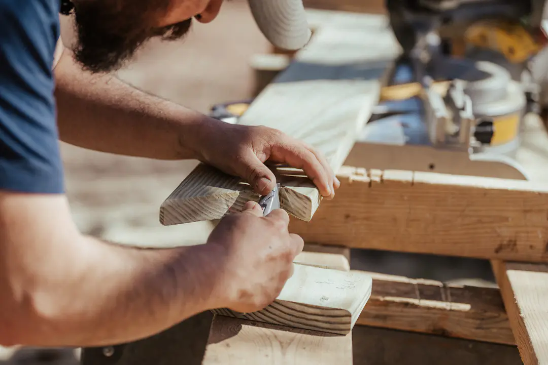 Person bearbeitet Holz für ein selbst gebautes Outdoor Spiel