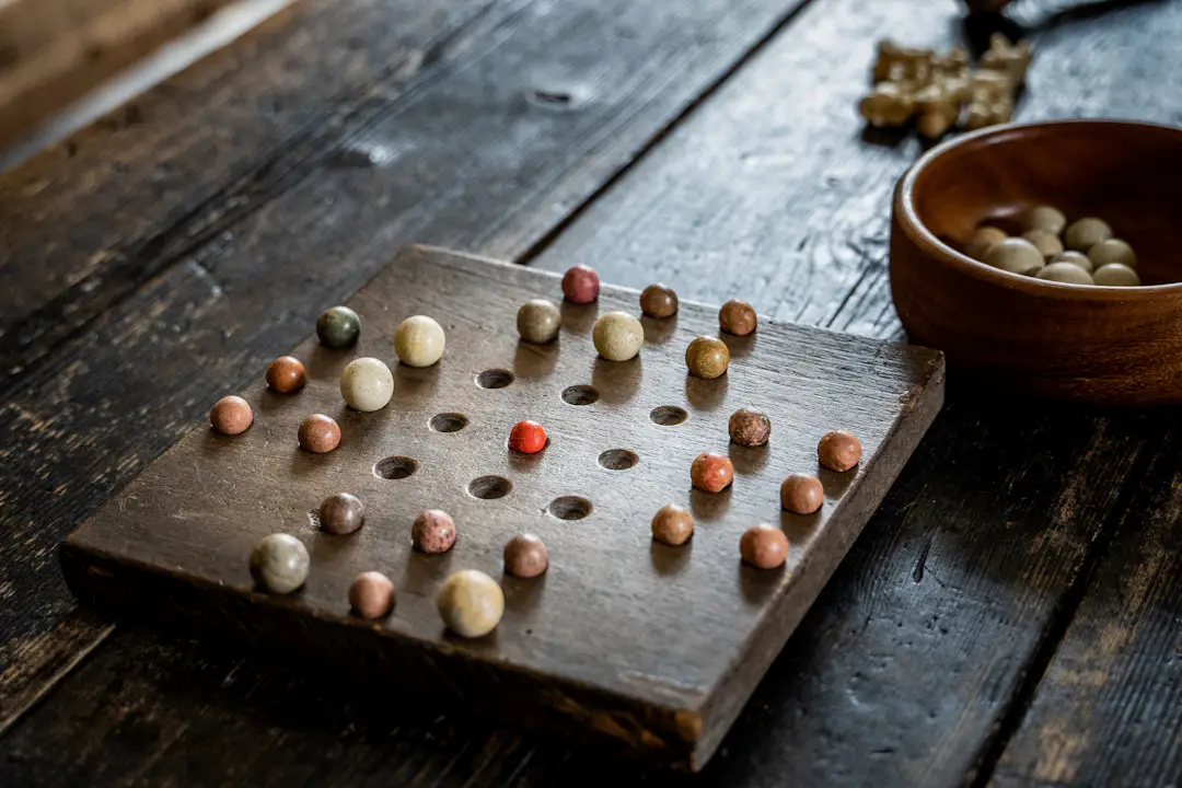Holzspiel mit Kugeln und Vertiefungen auf einem Spielbrett