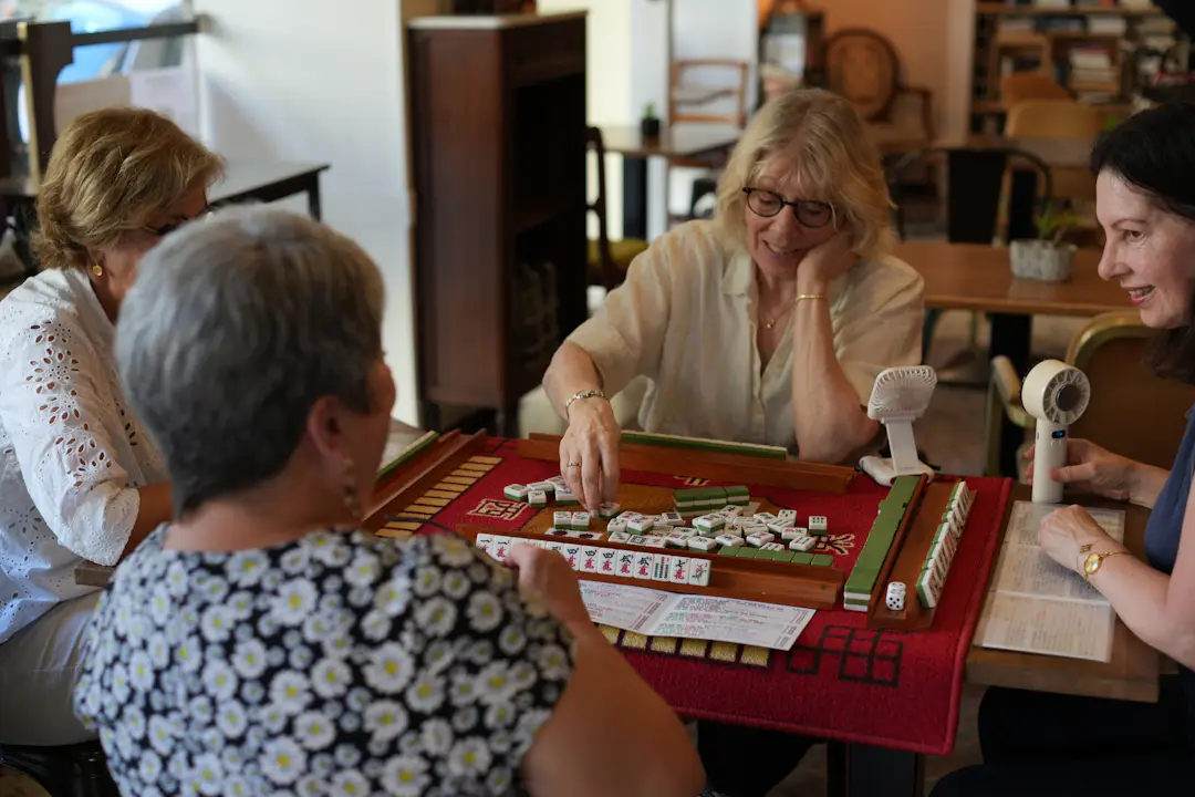 Ältere Erwachsene spielen gemeinsam Mahjong am Tisch
