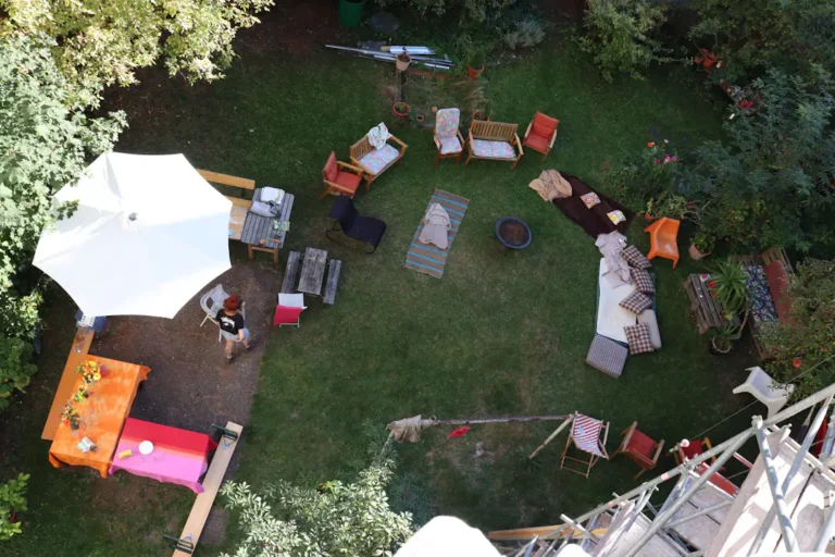 Vorbereiteter Garten für eine Feier mit Sitzmöbeln und Sonnenschirm