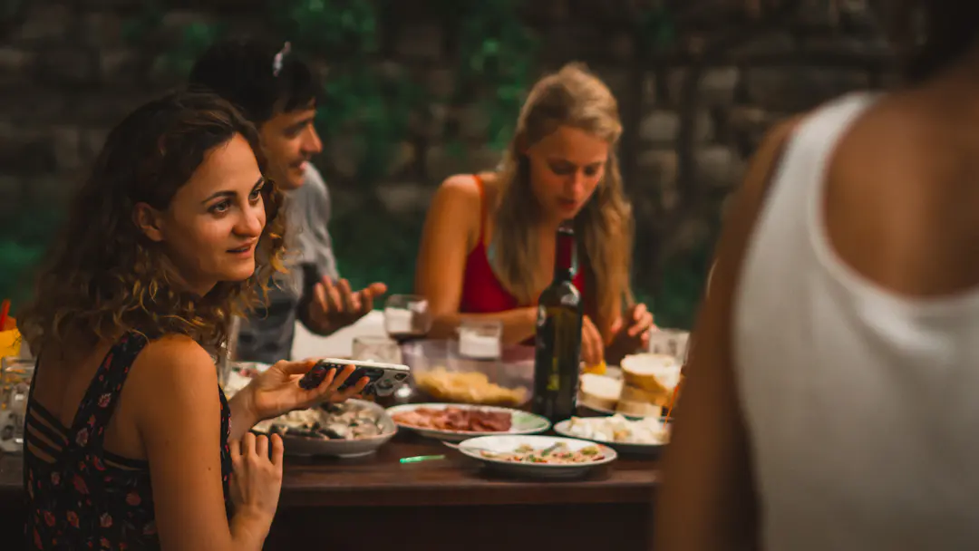 Erwachsene verbringen gemeinsam einen langen Abend an einem gedeckten Tisch