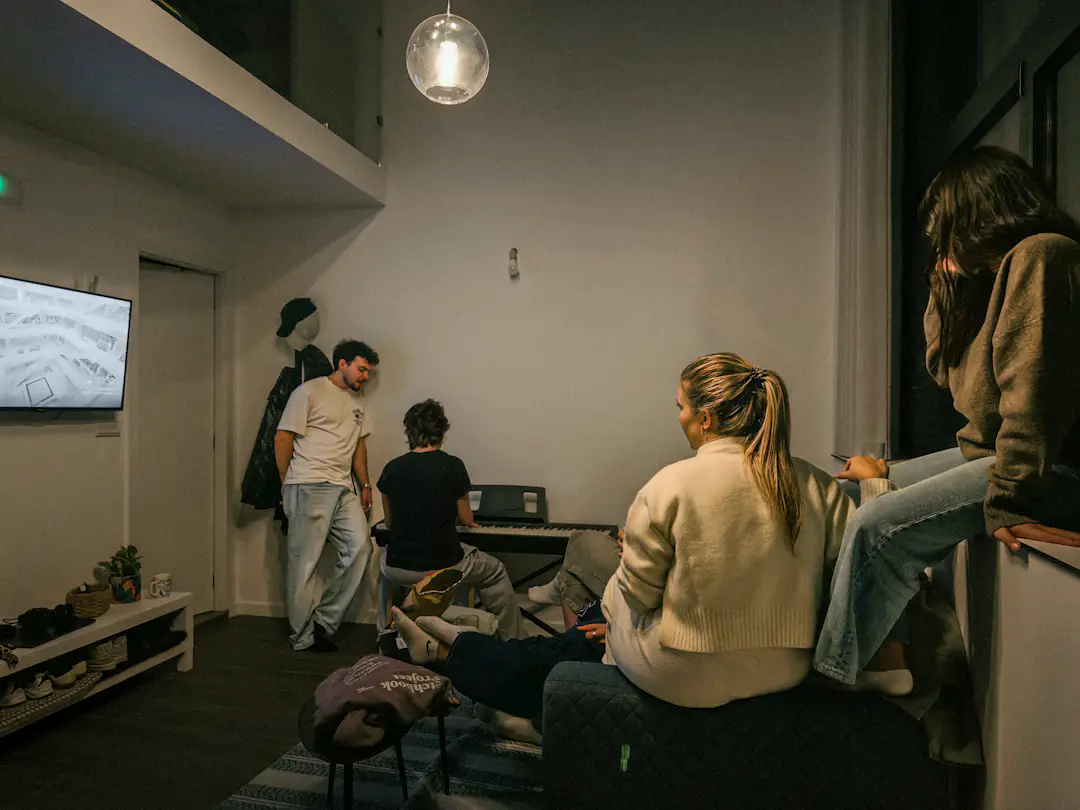 Gruppe von Freunden sitzt gemeinsam in einem Wohnzimmer