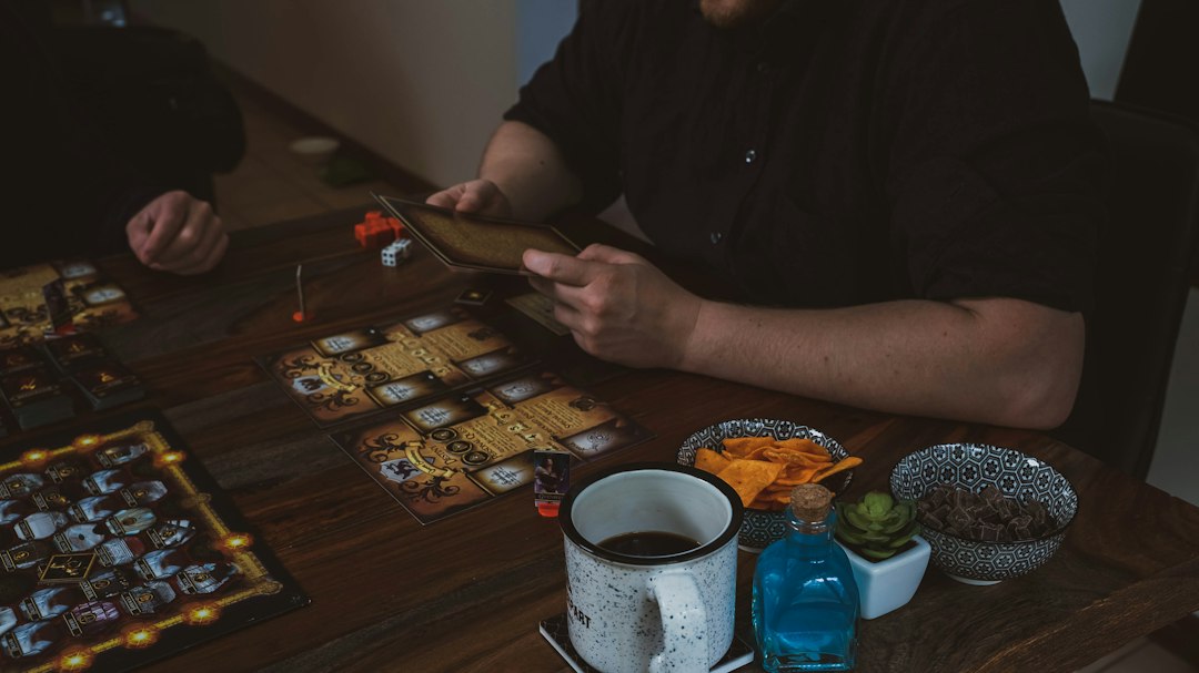 Freunde spielen gemeinsam ein Brettspiel mit Snacks am Tisch