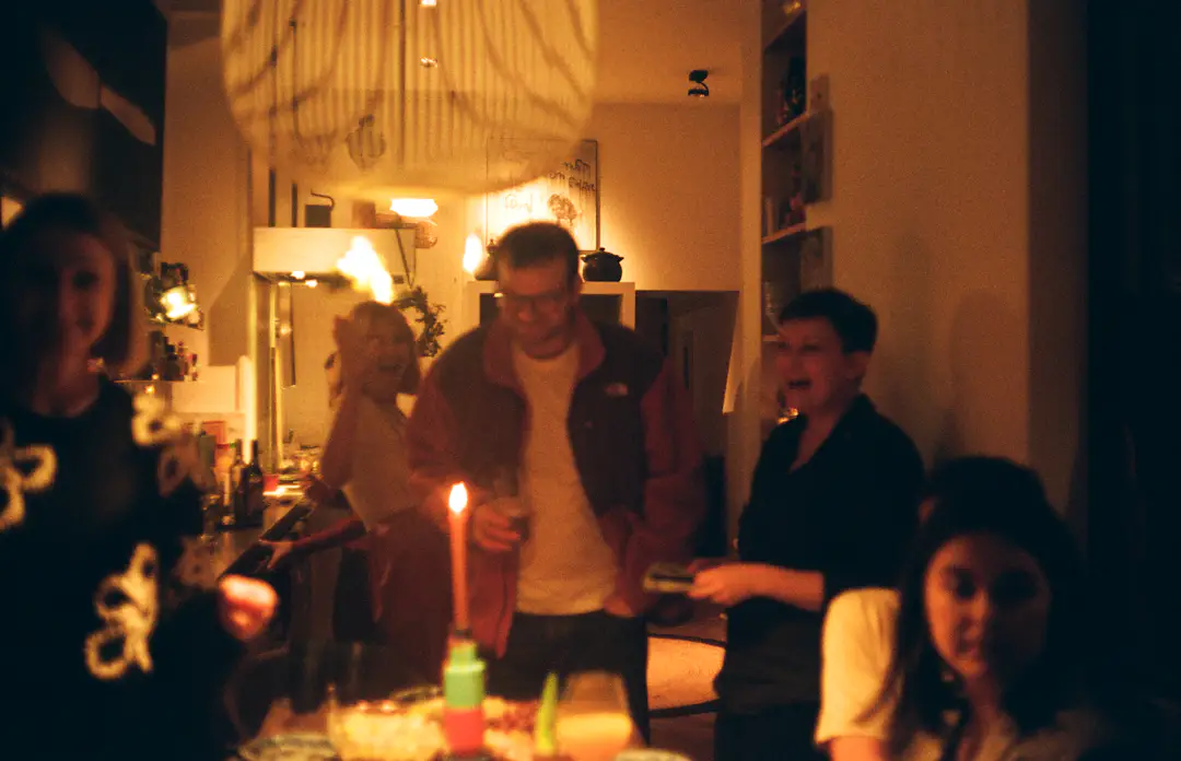 Freunde sitzen bei Kerzenlicht gemeinsam an einem Tisch