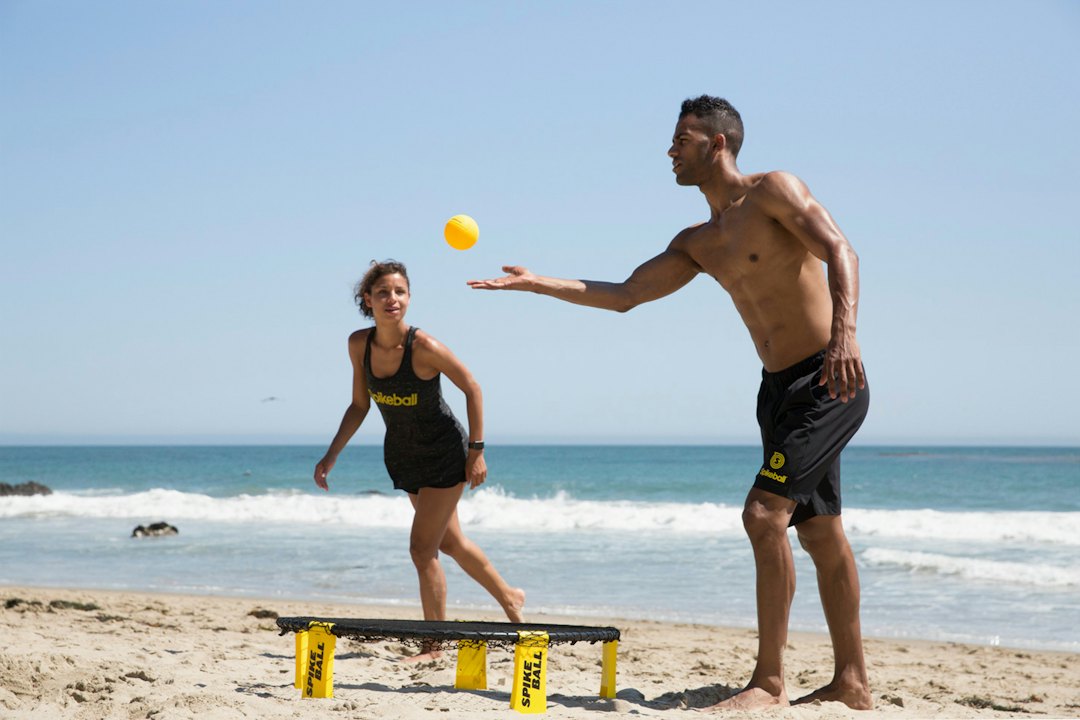 Freunde spielen gemeinsam ein Wurf- und Ballspiel am Strand